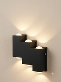 A black wall light unit with a stepped geometric design in the shape of a ladder, providing double lighting (up and down) via spherical lenses.
