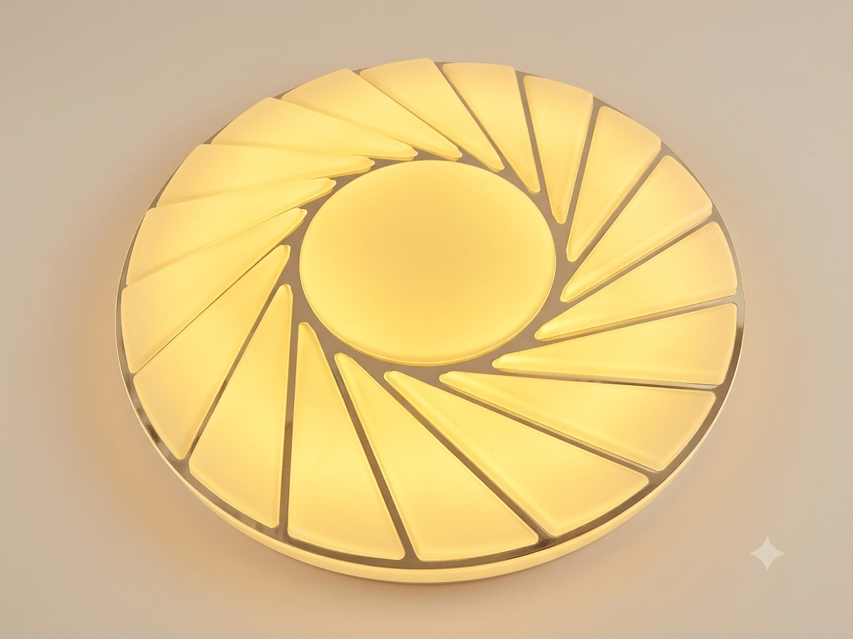 A circular ceiling light unit with a spiral radial design resembling sunlight or a turbine fan, providing warm lighting.