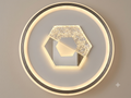 A modern circular light unit featuring an external LED ring and a hexagonal geometric design in the center, partially studded with sparkling crystal.