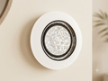 An elegant circular wall light unit, featuring an outer white light ring and a center decorated with ribbed crystal glass that sparkles within a black frame.