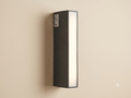 A linear wall sconce with a modern black rectangular design and an extended white light front.