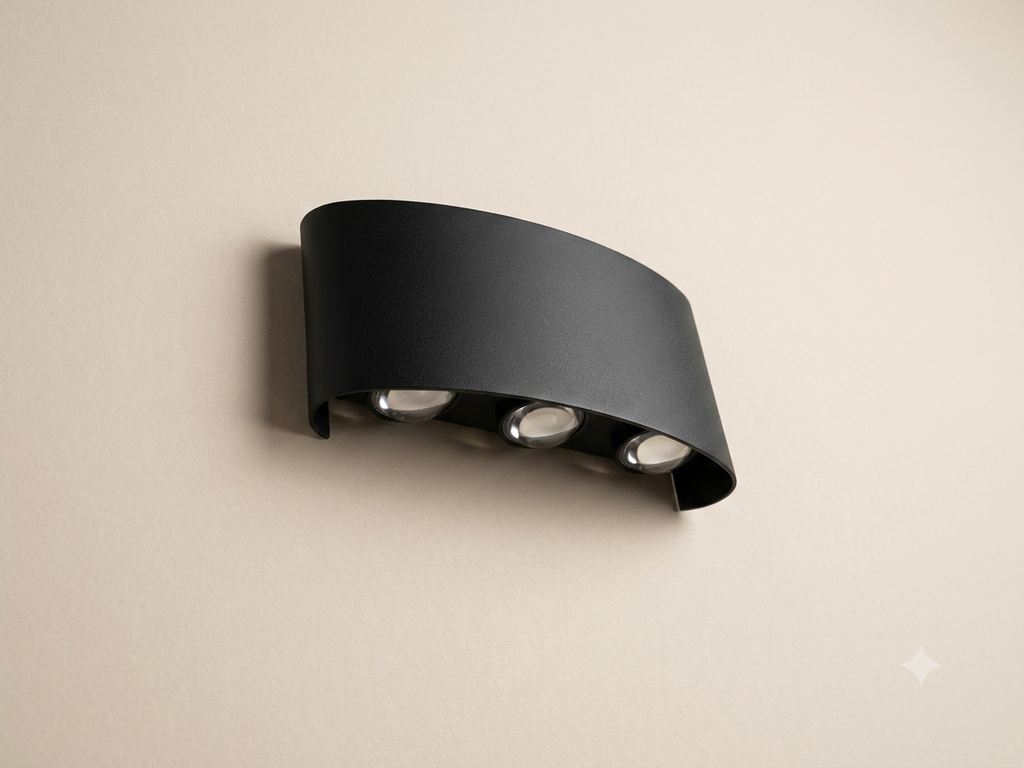 A gold wall sconce with an elegant curved metal design featuring three spherical bulbs that distribute light upwards.