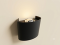 A black curved wall sconce light unit featuring a reflective metal sphere bulb that provides soft overhead lighting.