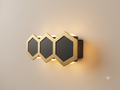 Decorative LED wall lamp in a hexagonal shape, in gold and black.