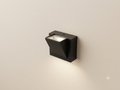 A black wall sconce with a modern geometric design that directs light up and down.