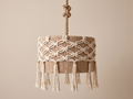 A cylindrical hanging chandelier made of burlap and macramé.