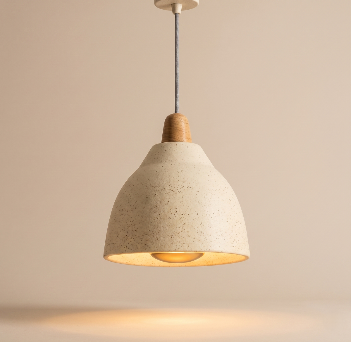 A pendant light unit with a streamlined design inspired by natural shapes, combining the warmth of wood and the dotted ceramic texture to add a calming touch to the architectural space.