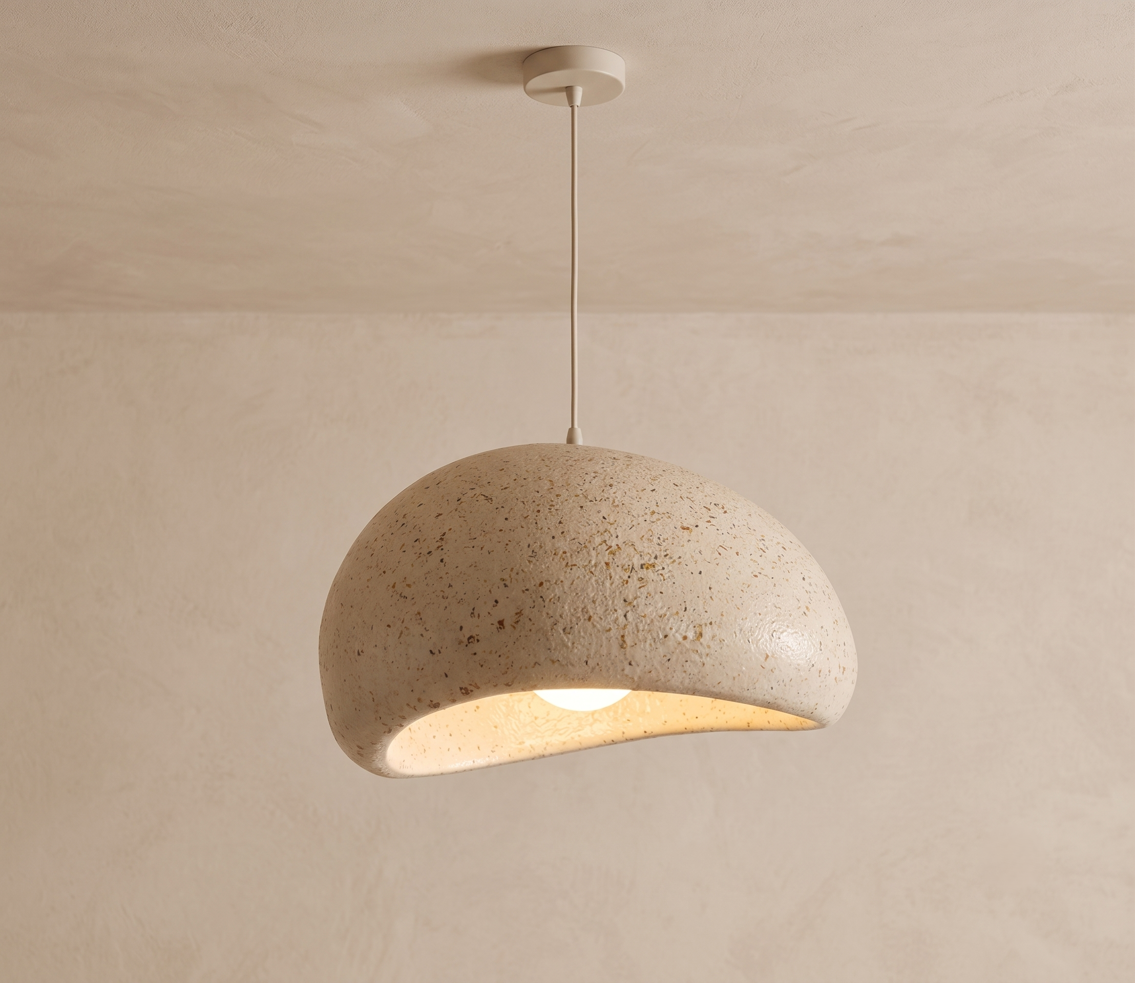 A pendant lamp with an organic, curved design and a rough, textured finish resembling natural stone.