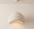 A pendant lamp with an organic design and a finish resembling natural terrazzo.
