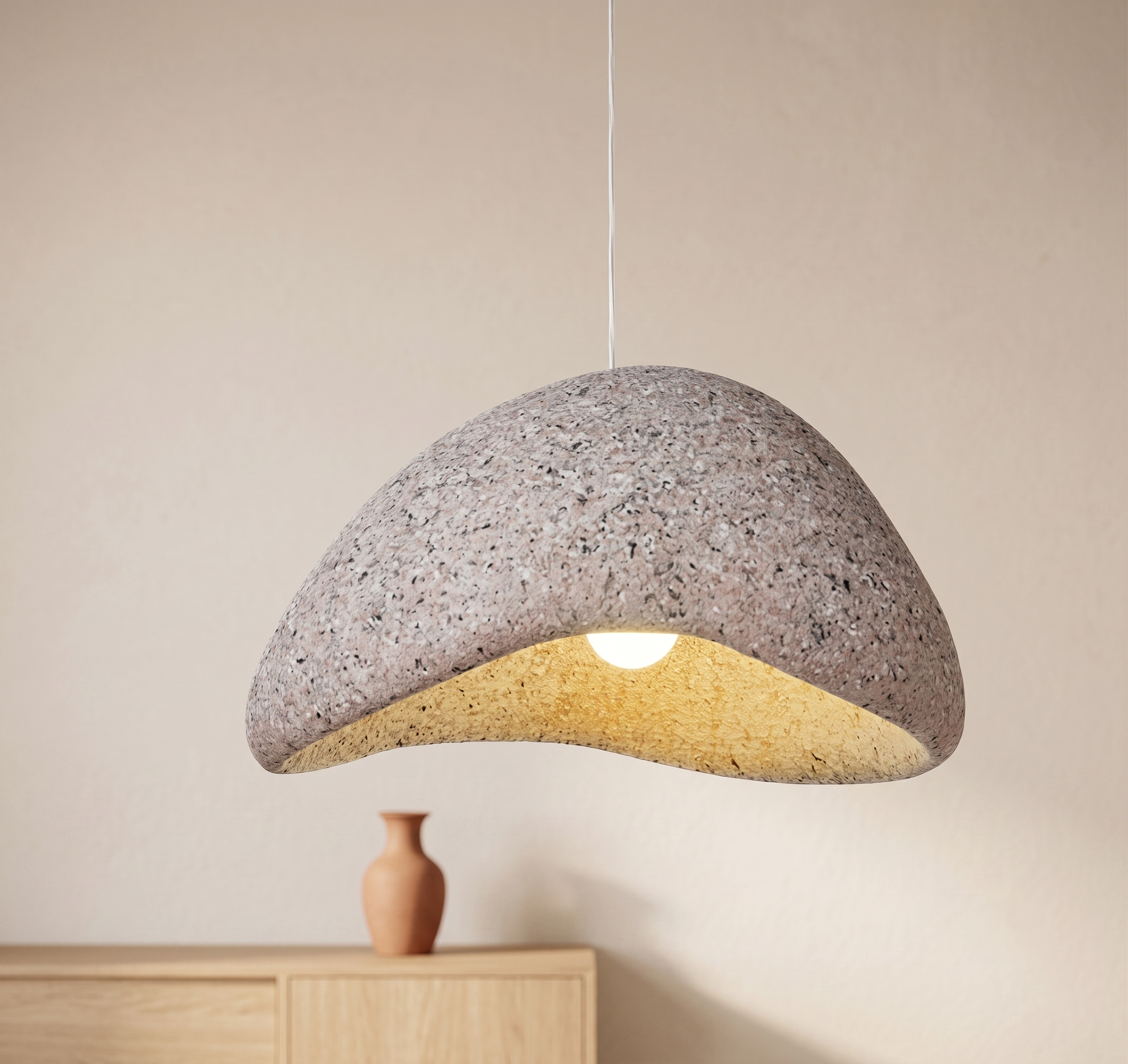 A pendant lamp with a streamlined design resembling natural rock with a pleasing texture.