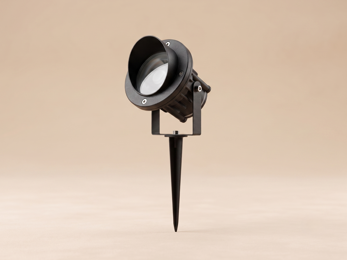 A recessed lighting unit (Spike Light) for ground mounting, with a black metal design and lens protector.
