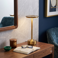 A stylish metal table lamp with a gold finish, featuring a modern flat-top design and a slim, textured pole, providing warm, downward-facing lighting ideal for reading or as ambient lighting.