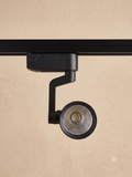 A black track light with a sleek and modern design, mounted on a track.