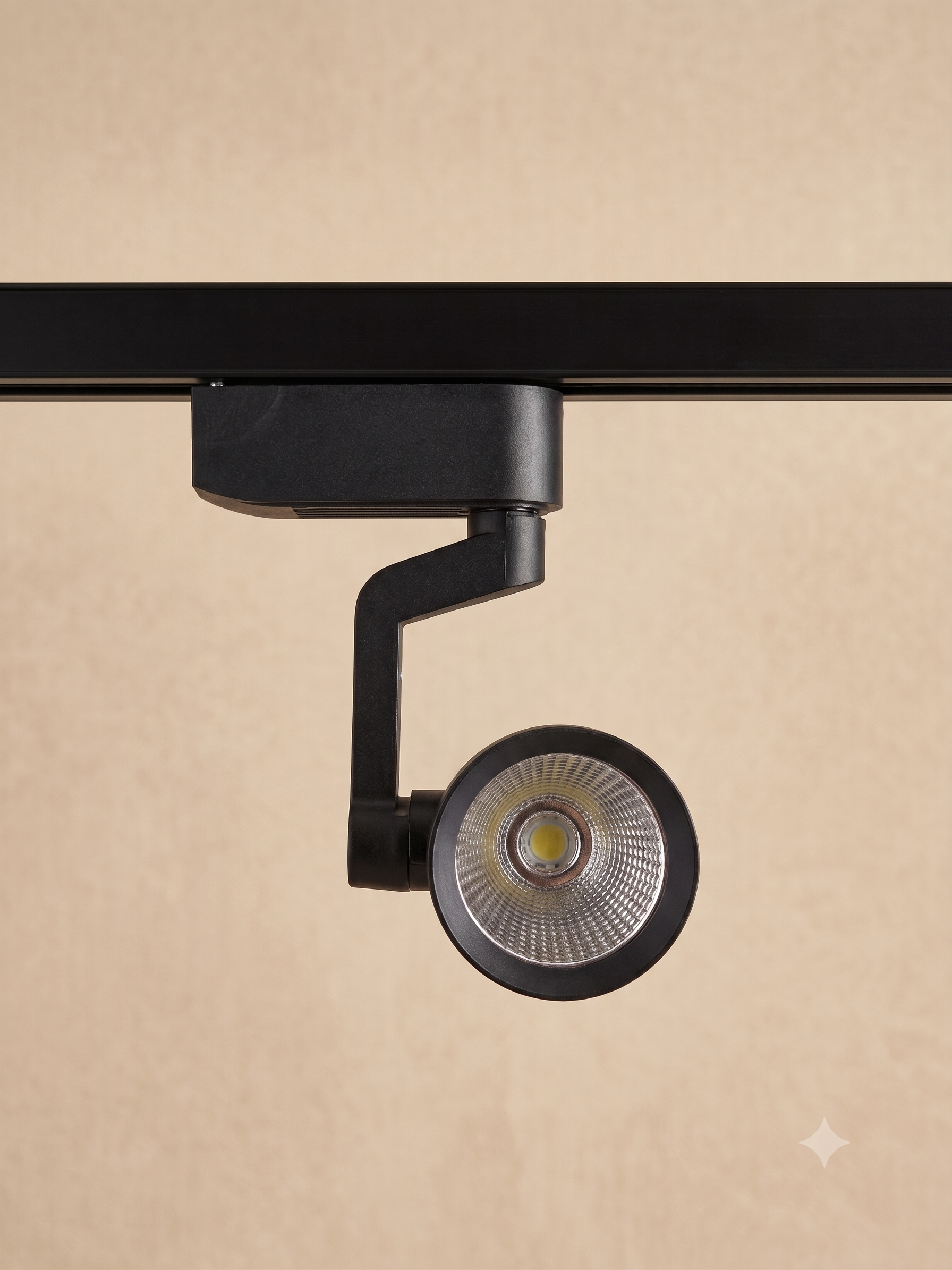 A black track light with a sleek and modern design, mounted on a track.
