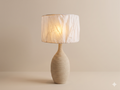 A ceramic table lamp with a raised beige texture and a white fabric cover.