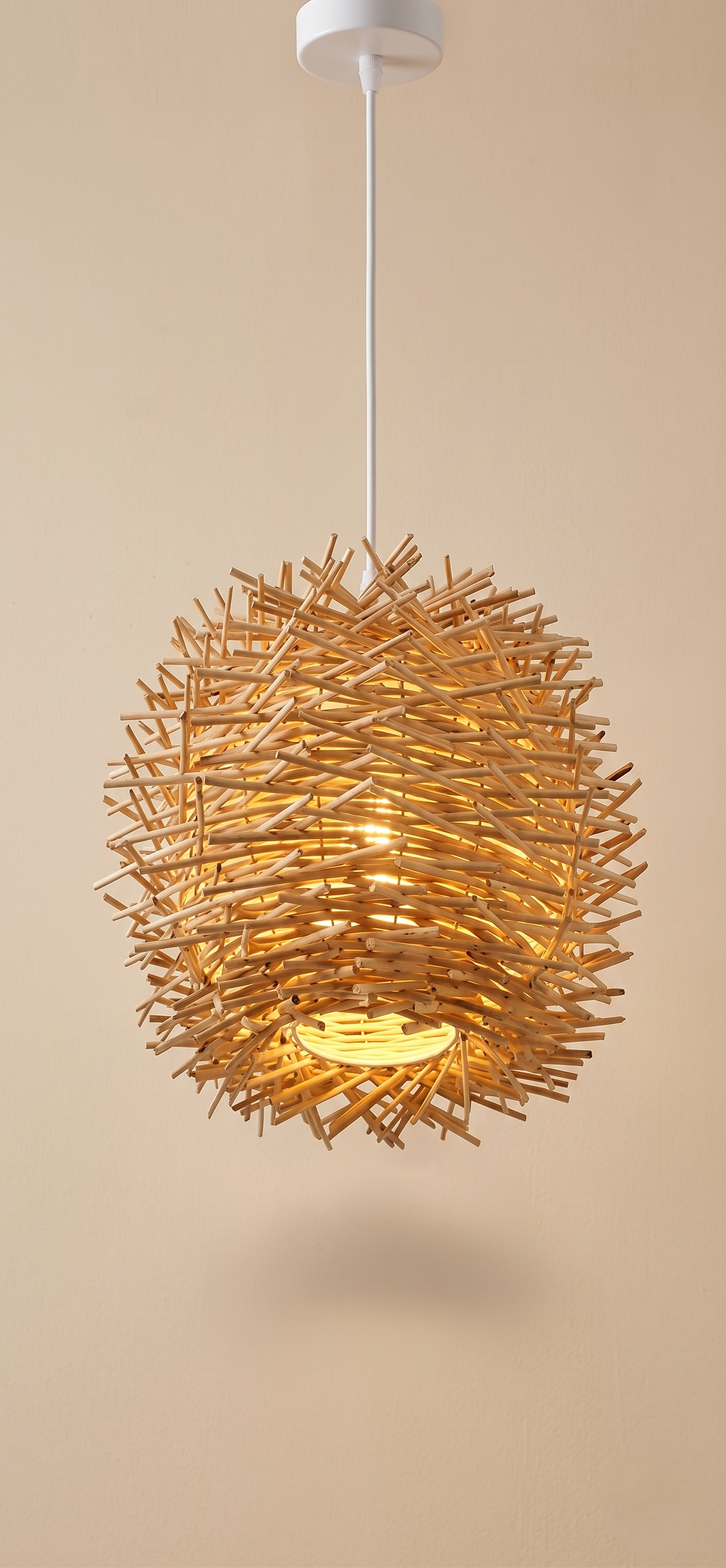 A pendant light with a spherical design inspired by birds' nests, made from intertwined wooden branches.