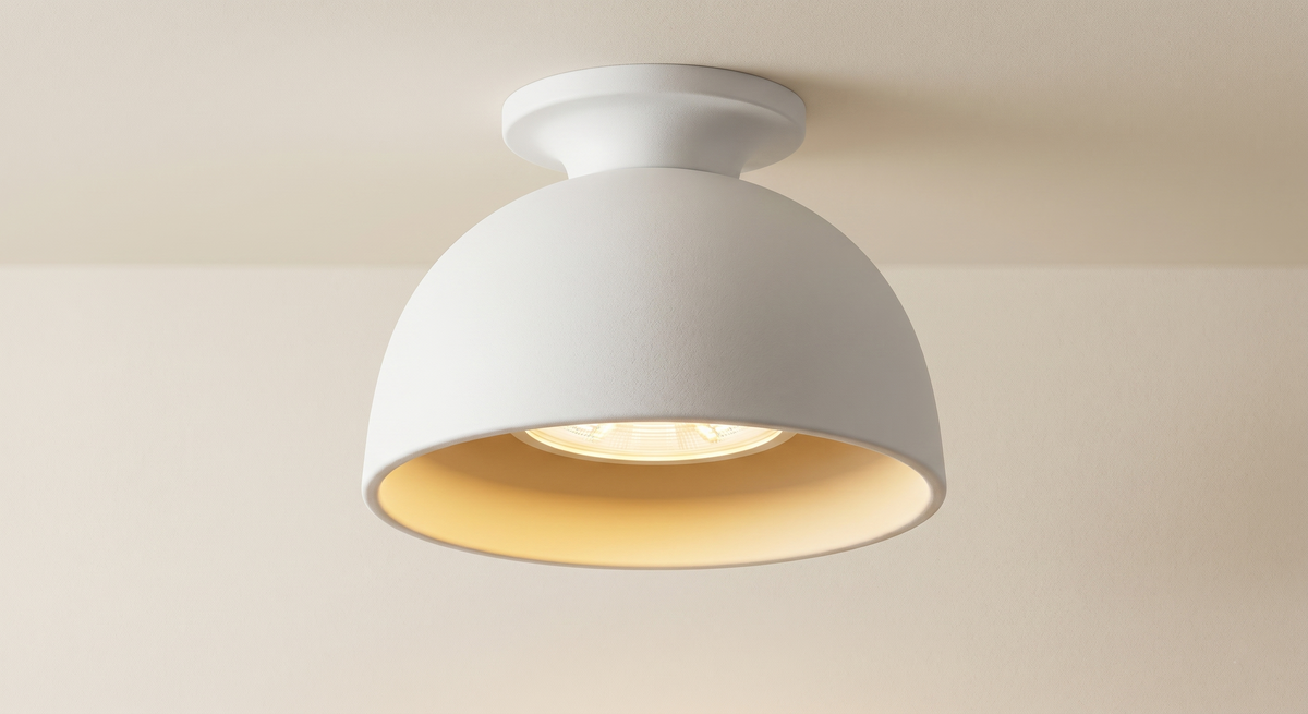 A soft ceiling light fixture with a matte white finish, its clean lines reflect the Bauhaus philosophy of combining function with aesthetic simplicity to distribute warm and comfortable lighting in the space.